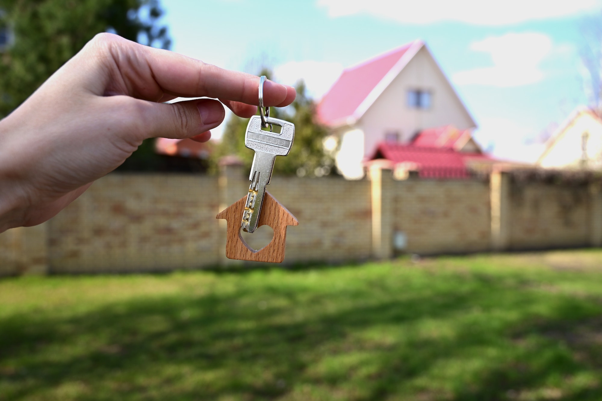a key with a keychain in the form of a house with a heart on the background of the finished year of